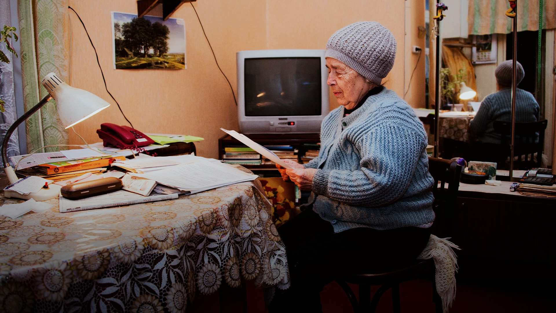 elderly woman looking at old documents